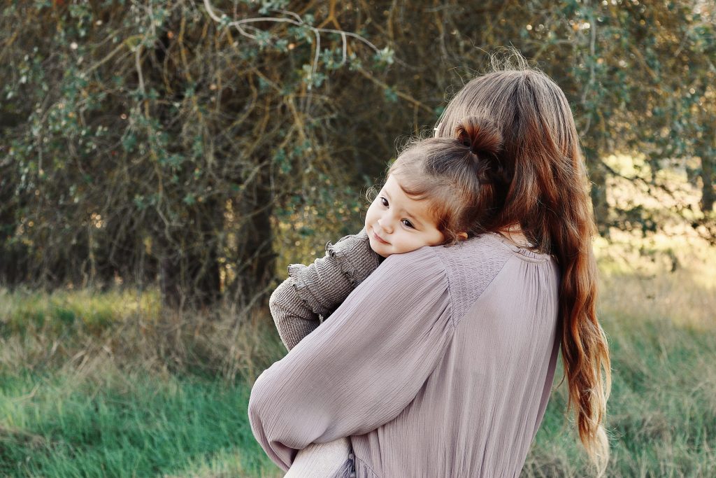 Mother embracing her child in a field of grass