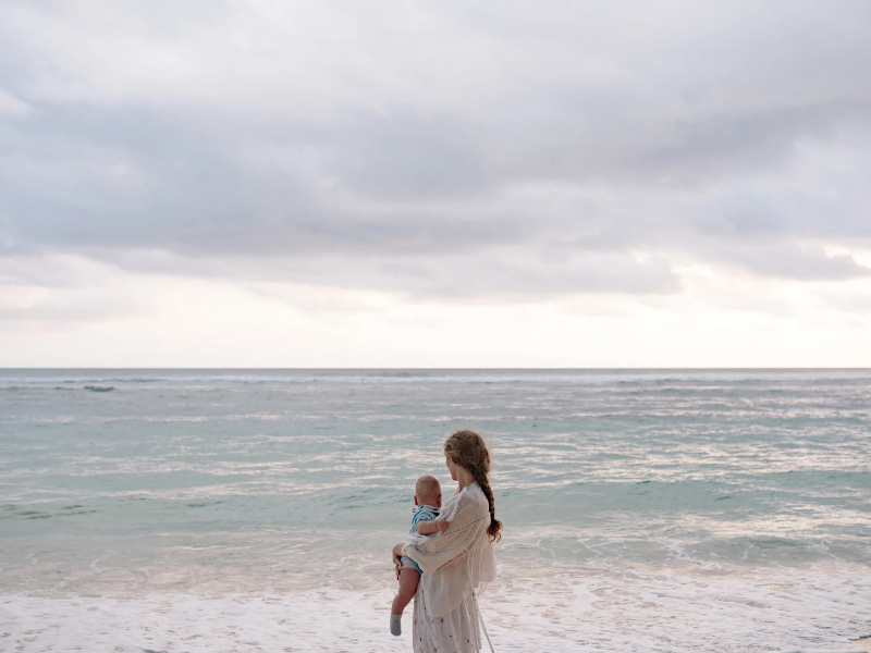 mother holding her baby at the beach